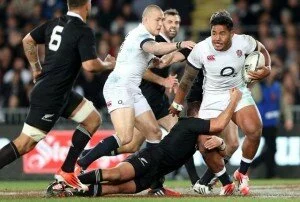 New Zealand All Blacks player Aaron Cruden tackles England's Manusamoa Tuilagi (R) as Mike Brown looks on (C) during their rugby union match at Eden Park in Auckland on June 7, 2014. The All Blacks beat England 20-15. AFP PHOTO / Michael Bradley